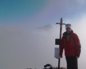 Der verschneite Ötschergipfel schaut aus der Nebeldecke heraus